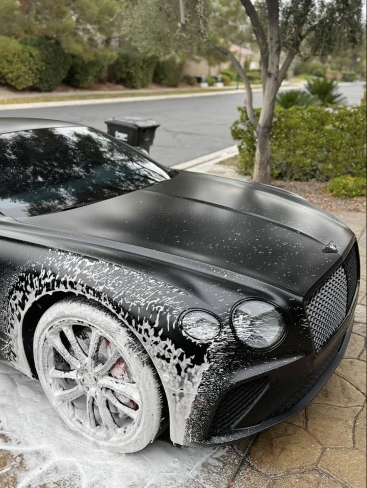 Matte black Bentley covered in foam during a hand wash
