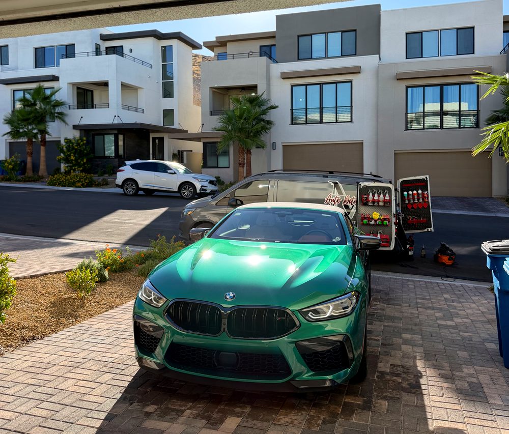 Green BMW M8 with a glossy finish after paint correction, Martinez Auto Detail van behind it
